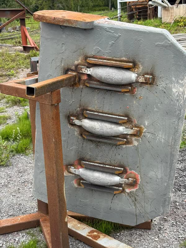 The removed rudder blade on its stand, with three zinc anodes fitted