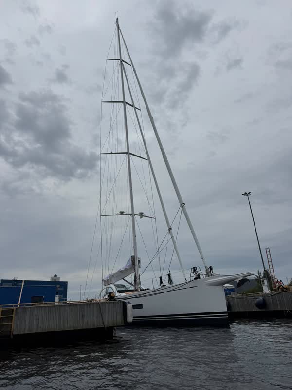 Die Swan 108 von Tom Cruise von der Seite: schlanker weißer Rumpf mit dunklem Zierstreifen und hoher Kohlefasermast an der Nautor-Swan-Werft in Finnland