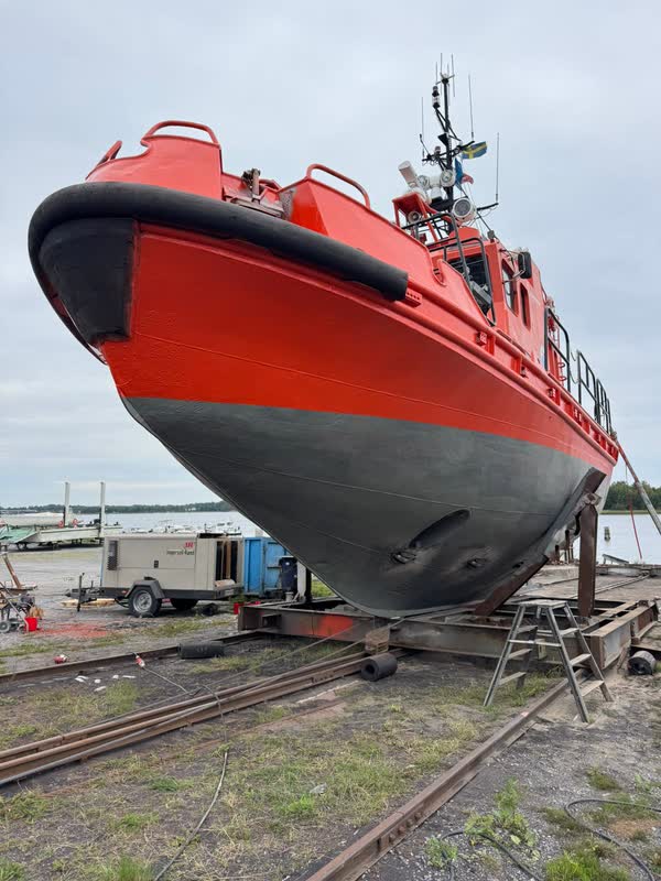 The rounded hull of the pilot boat with the draught marks on the bow